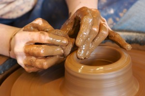 Picture of a pot being created and evolved on a pottery wheel.